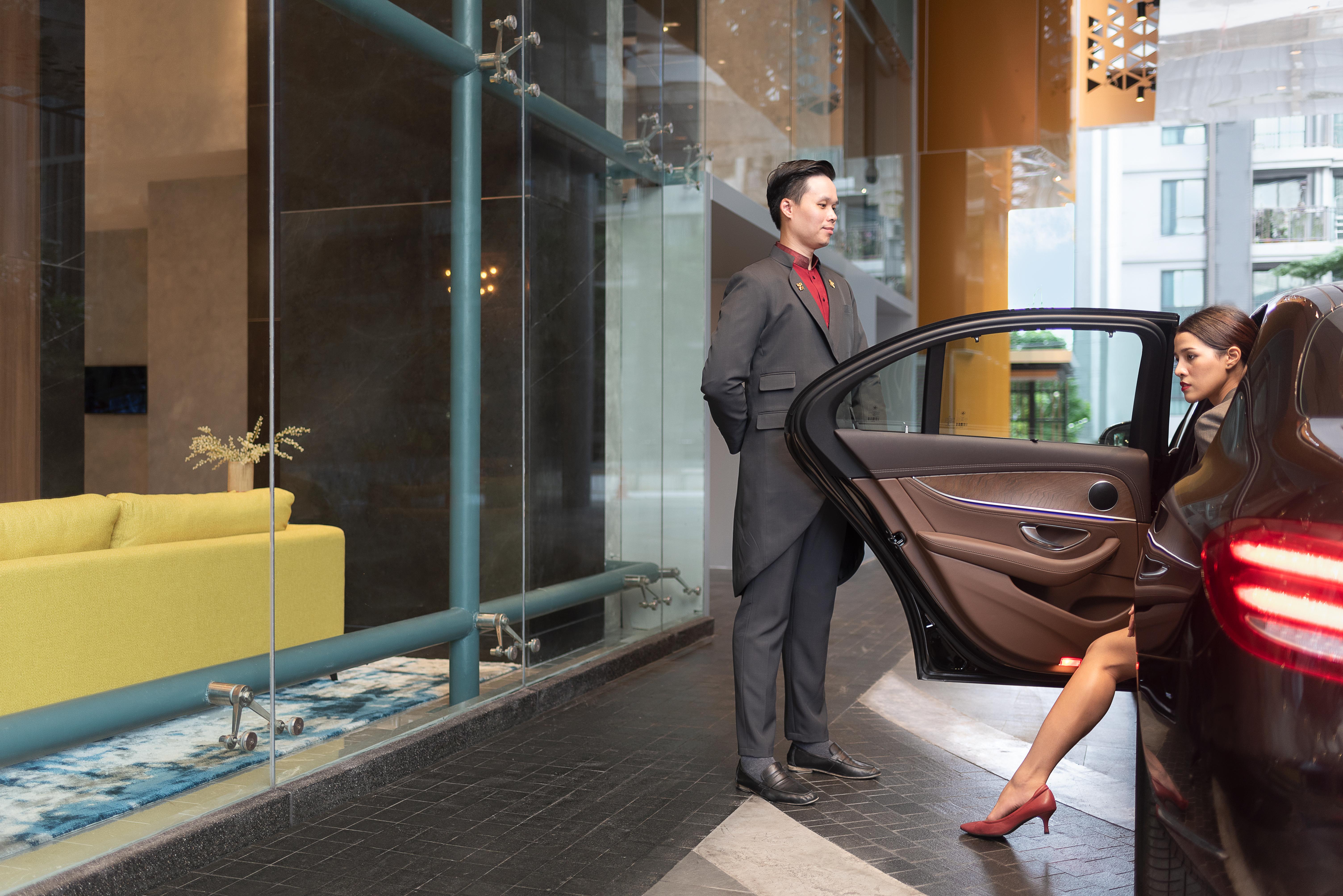 Avani Sukhumvit Bangkok Hotel Zewnętrze zdjęcie A doorman opening a car door for a guest